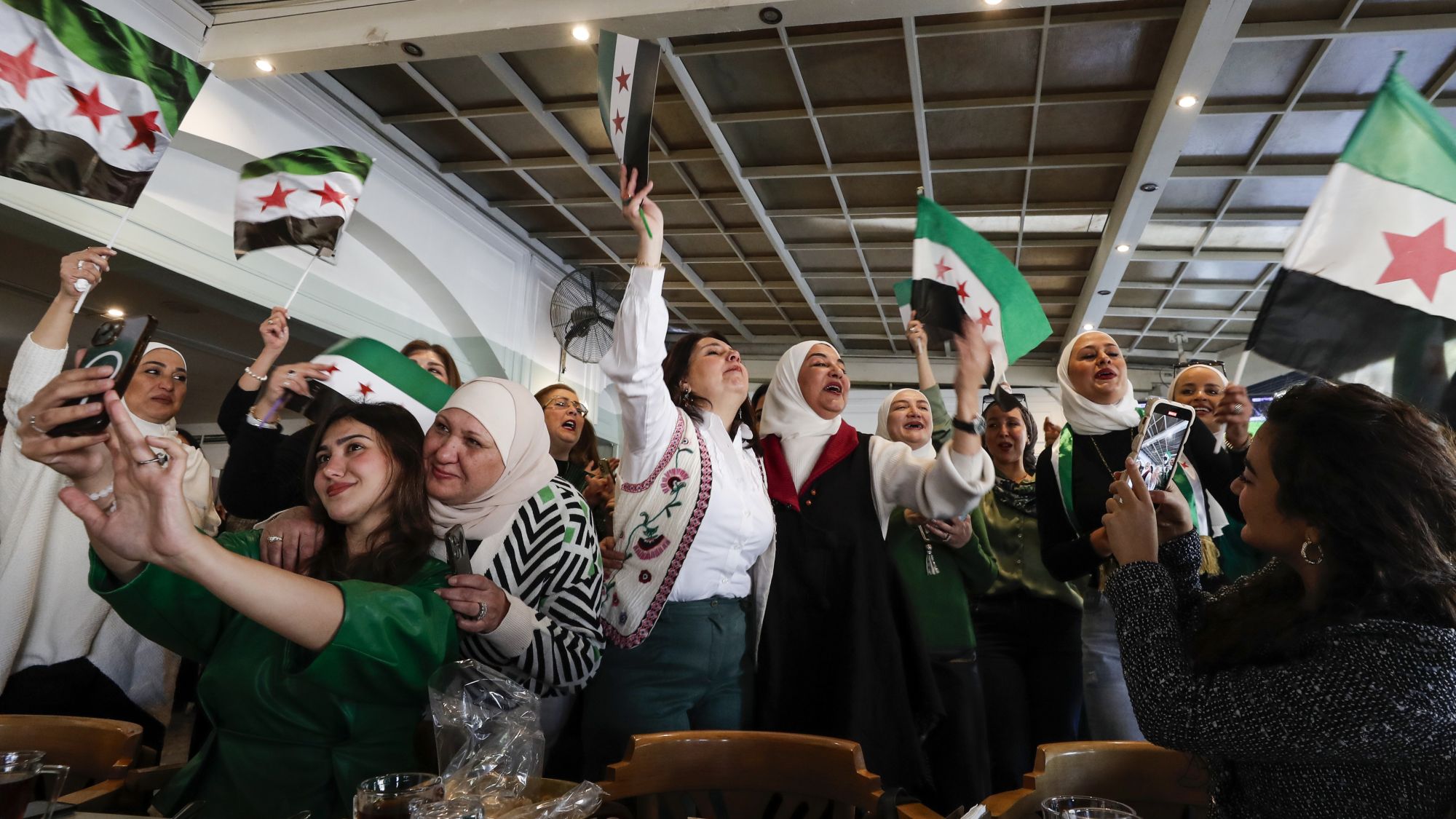 (Foto: Picture Alliance / AP | O. Sanadiki) Frauen feiern mit den Flaggen des neuen Syriens.