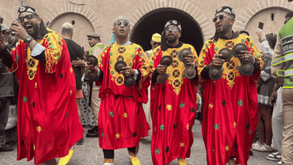 Qraqeb players at the Gnaoua and World Music Festival in Essaouira, June 2025. (Photo: Vanessa Barisch) Four Gnaoua musicians walk through Essaouira with castanets and in red robes decorated with yellow and green embroidery.